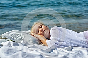 Sleeping little girl on the seashore