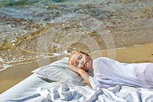 Sleeping little girl on the seashore