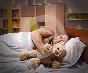 Sleeping man in bed with toy bear