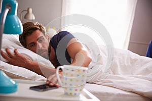 Sleeping Man Being Woken By Mobile Phone In Bedroom