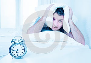 Sleeping man disturbed by alarm clock early mornin