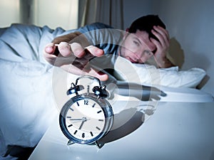 Sleeping man disturbed by alarm clock early mornin photo