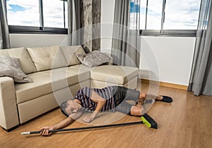 Sleeping man on the floor with a broom in his hand