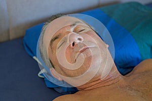 Sleeping middle aged man with a nose tape and a mouth tape