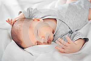 Sleeping newborn baby boy in bed