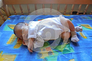 Sleeping newborn baby boy in bedstead