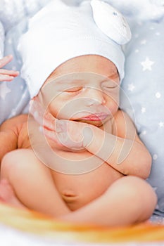 Sleeping newborn baby boy with funny hat. Babyface close-up. Very sweet infant photo
