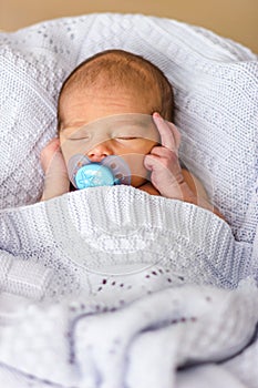 Sleeping newborn baby boy with pacifier. Babyface close-up