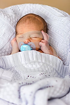 Sleeping newborn baby boy with pacifier. Babyface close-up photo