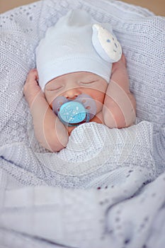Sleeping newborn baby boy with pacifier. Babyface close-up photo