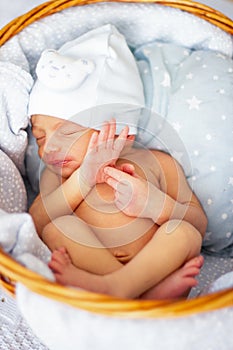 Sleeping newborn baby boy in wicker basket. Babyface close-up. Very sweet infant