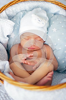 Sleeping newborn baby boy in wicker basket. Babyface close-up. Very sweet infant