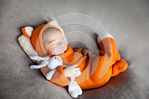 Sleeping newborn baby in cute fox outfit