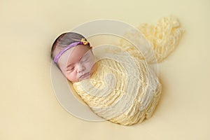 Sleeping Newborn Baby Girl Swaddled in Yellow