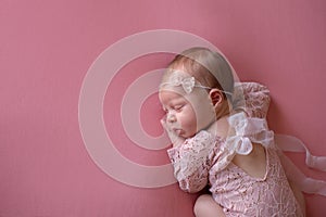 Sleeping Newborn Baby Girl Wearing a Pink Lace Romper photo