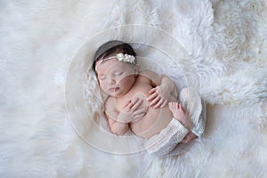 Sleeping Newborn Baby Girl on White Sheepskin Rug