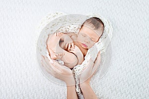 Sleeping newborn baby  in mother hands - hearth shape