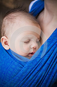 Sleeping newborn baby in the sling