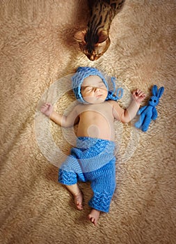 Sleeping newborn in blue cap and pants