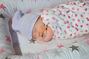 Sleeping newborn caucasian baby with hat.