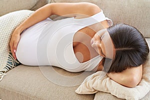 Sleeping pregnant woman embracing belly