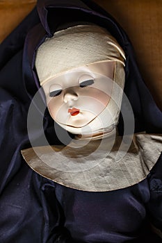 Sleeping retro nun doll in wimple and blue gown