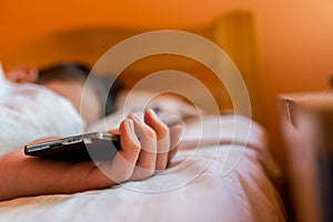 Sleeping teenage boy holding hes smartphone, conceptual image