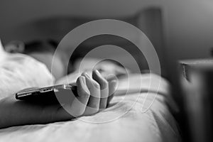 Sleeping teenage boy holding hes smartphone, conceptual image of smartphone addiction