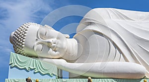 Sleeping white Buddha statue with blue sky background