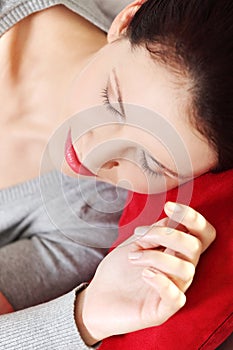 Sleeping woman lying on a red pillow.