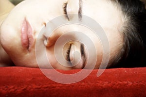 Sleeping woman on a red pillow