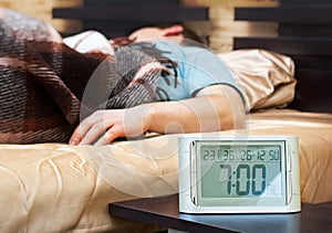 Sleeping young man with alarm clock