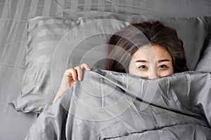 Sleepless Asian woman insomnia, overthinking lying down in bed late at night with dark eye circle