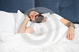 Sleepless night. Sleep disorders concept. Man bearded hipster having problems with sleep. Guy lying in bed try to relax