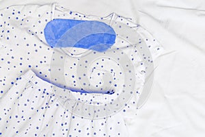 Sleepwear for slumber. White summer pajamas for men. Blue Sleeping mask on white sheet in bedroom