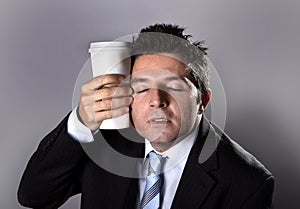 Sleepy addict businessman holding take away coffee in caffeine addiction photo