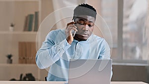 Sleepy african man young male employee investor businessman napping at office desk abruptly wake up shocked confused