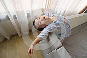 Sleepy Asian baby boy stretching and closed eyes after waking up at home