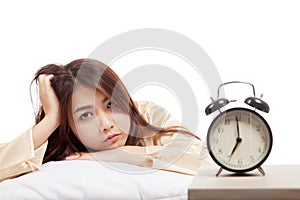 Sleepy Asian girl wake up with pillow and alarm clock