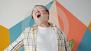 Sleepy Asian mature man yawning feeling fatigue and sleepiness at home studio