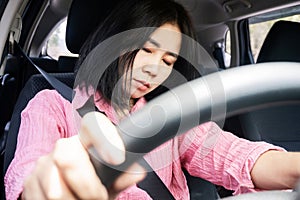 Sleepy Asian Woman Falls Asleep while Driving, the Danger of Drowsy Driving, unsafe driving behavior concept