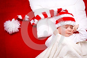 Sleepy baby on red blanket