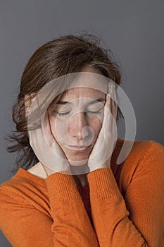 Sleepy beautiful middle aged woman holding her face for reassurance photo