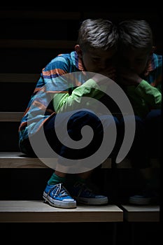 Sleepy boy on stairs at night