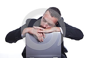 Sleepy businessman with his laptop taking break