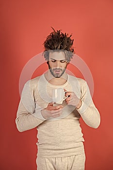 Sleepy guy with tea cup on red background.