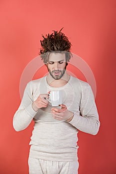 Sleepy guy with tea cup on red background.