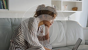 Sleepy lady using laptop in pajamas closeup. Office worker stretch yawn indoors