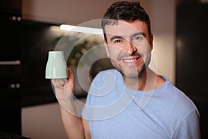 Sleepy looking man holding coffee cup upside down