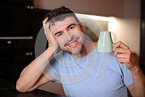 Sleepy looking man holding coffee cup upside down